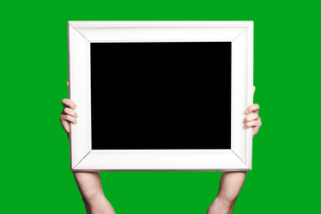 Hands holding empty copy space wooden frame isolated on green screen.