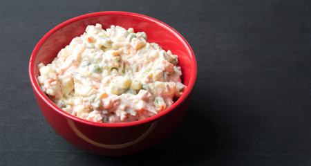 russian salad in a red bowl