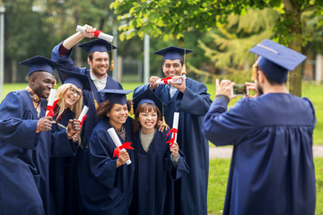 students or bachelors photographing by smartphone