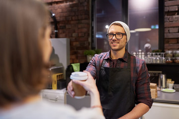seller giving coffee cup to woman customer at cafe