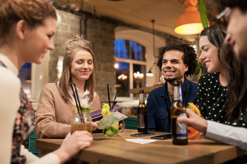 friends with drinks, money and bill at bar