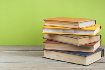 Stack of colorful books on wooden desk, free copy space. Back to school. Education background