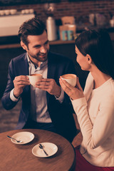 Happy romantic man and woman  sitting in a cafe drinking coffee