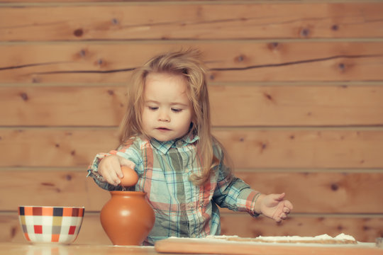cute child cooking with dough, flour, egg and bowl