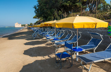 Fototapeta na wymiar Rows of umbrellas and chairs on a beautiful beach