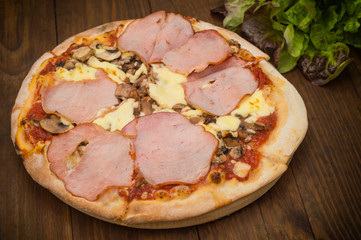 Pizza with bacon ham, mushrooms and sausage. Wooden background. Top view. Close-up