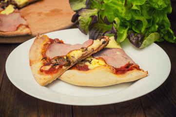 Pizza with bacon ham, mushrooms and sausage. Wooden background. Top view. Close-up