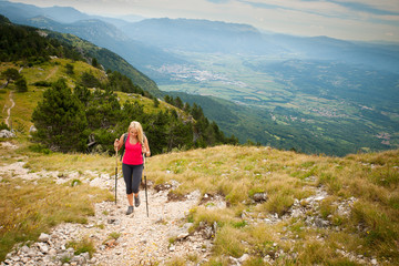 Obraz premium Trekking - woman hiking in mountains on a calm sumer day