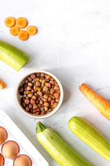 petfood set with vegetables and eggs on kitchen table top view mockup