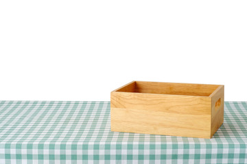 Empty wooden storage box on green checked tablecloth isolated on white background, product display montage