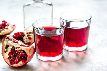 bottle of pomegranate juice with slices on stone table