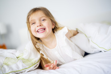 Naklejka premium Adorable little girl waked up in her bed