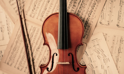 Fototapeta na wymiar Violin lying on the old music notes