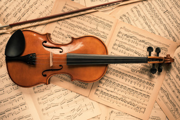 Fototapeta na wymiar Violin lying on the old music notes