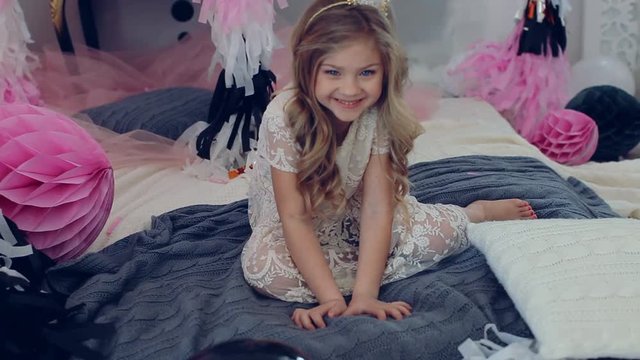 portrait of little baby girl smiling on the day of birth in a dress with colorful balloons. Excited kid celebrating her birthday