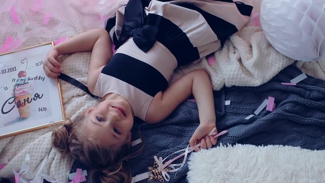 Beautiful little girl with long hair. View from above. Celebration. In his hand holds a magic wand