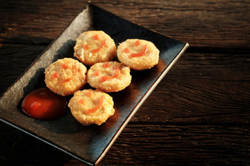 Happy snack with Chicken nugget with smile tomato sauce in black plate rough wooden 