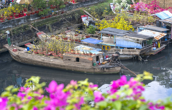 Ho Chi Minh City, Vietnam - January 26, 2017: Flowers boats at flower market on along canal wharf. This is place where farmers sell apricot blossom and other flowers on Lunar New Year in Vietnam