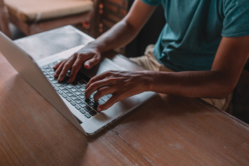 Close up, hands are typing on a keyboard of laptop - macbook