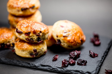 Traditional delicious British pastry and desert - scones with dry cranberry in black background.Home baking.