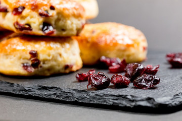 Traditional delicious British pastry and desert - scones with dry cranberry in black...