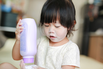 Little girl pour the talcum to the hand.