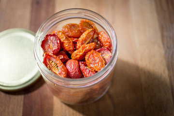 Roasted tomatoes in glass bottles.