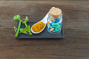 Spa herbal (white frangipani flowers, turmeric powder in white spoon ,pill,Cissus Quadrangularis Linn) on wooden background