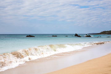 Soft blue ocean wave on sandy beach in Kenting, Taiwan.