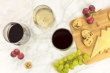 White and red wine with cheese, bread and grapes