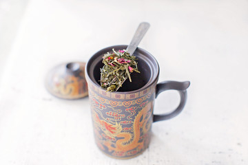 Obraz na płótnie Canvas Chinese cup with a spoon of loose leaf tea
