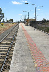 Fototapeta premium long train station platform alongside tracks