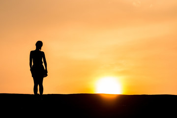 silhouette of Young woman relaxing in summer sunset sky outdoor. People freedom style.