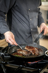 Chef frying pork meat