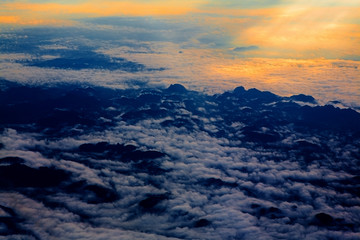 Fototapeta na wymiar aerial sky with clouds at sunset or sunrise. above from airplane over the mountain.