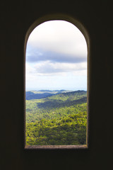 Beautiful view of the jungle woods and the Atlantic ocean through an old tower window in Puerto Rico.