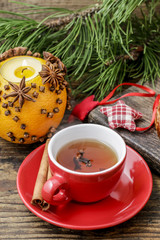 Obraz na płótnie Canvas Christmas tea with cloves. Orange pomander ball in the background.