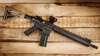black assault rifle on an old wooden table