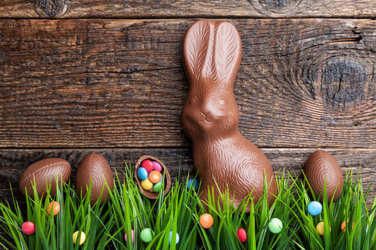 Chocolate Easter bunny and eggs on wooden background