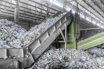 escalator with a pile of plastic bottles at the factory for processing and recycling. PET recycling...
