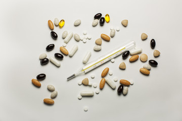 Thermometer, pills and vitamines isolated on a white background