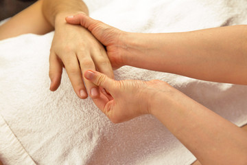 Hand massage with white towel, spa salon