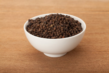 black peppercorns in white ceramic bowl