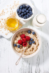 delicious homemade oatmeal with berries for breakfast, top view