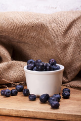 Pot of blueberries on a rustic background