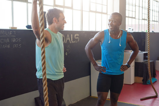 Friends chatting in gym with sun flare 