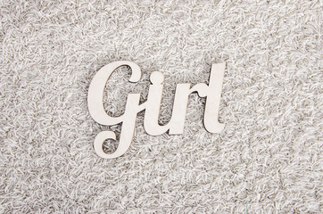 Fototapeta na wymiar Wooden letters inscription girl on the beige carpet .
