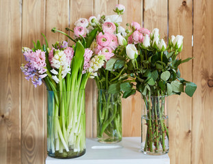 Bouquets of spring flowers on a wooden background. Roses and hyacinths on a wooden background