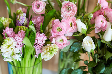 Bouquets of spring flowers on a wooden background. Roses and hyacinths on a wooden background