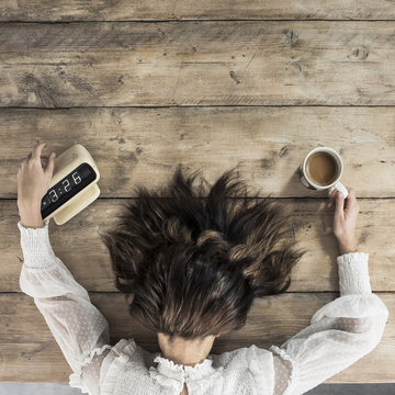 Tired young woman early morning alarm clock with coffee
